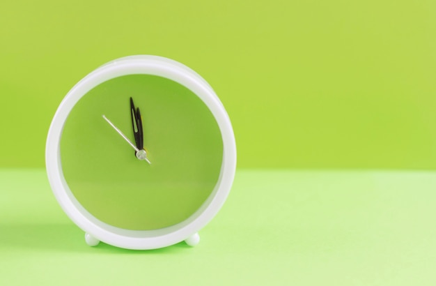 alarm clock with green dial on green background