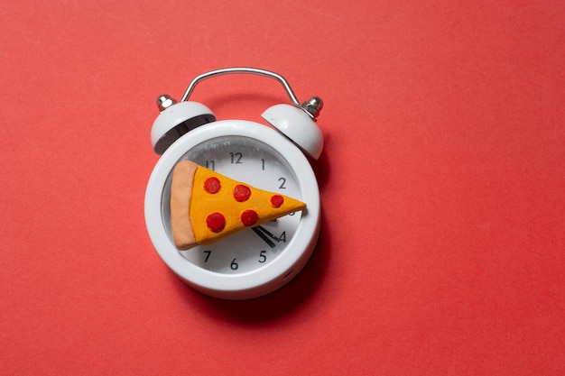 Alarm clock with a piece of pizza Pizza time Snack time