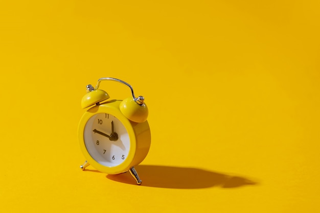 Alarm clock with two bells on yellow background