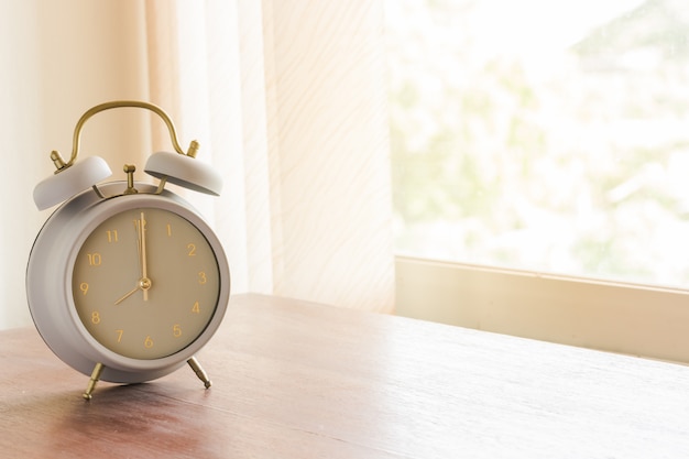 Alarm clock on wood table in the morning