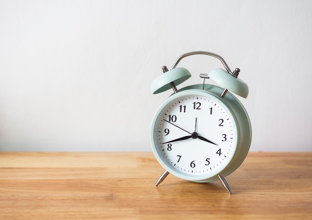 Alarm clock on wood table and white background.