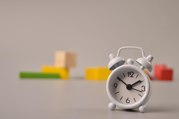 Alarm clock and wooden blocks with blurred background