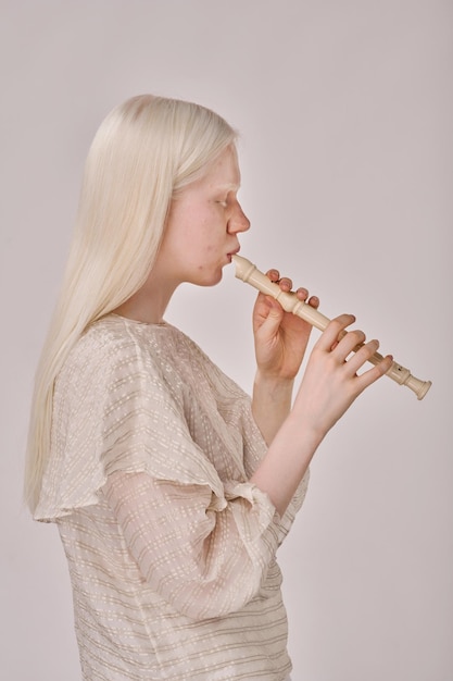 Albino girl playing on flute