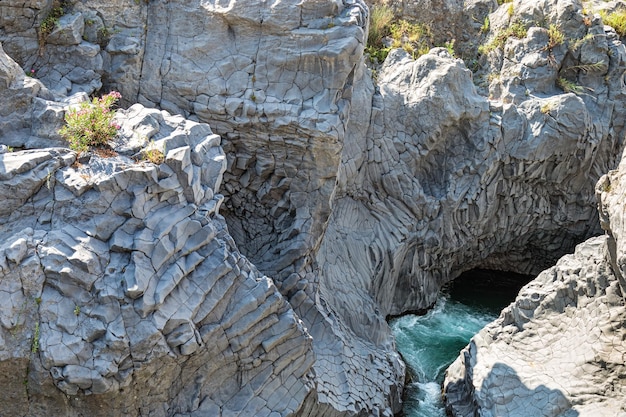 Alcantara Gorge and Alcantara river Park in Sicily island,  Italy. Beautiful mountain landscape. Black Volcanic stones around.