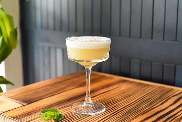 Alcohol cocktail Whisky sour on wooden table against dark wall with copy space