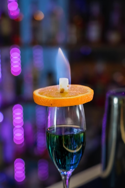 Alcohol cocktail with fire on a bar counter background