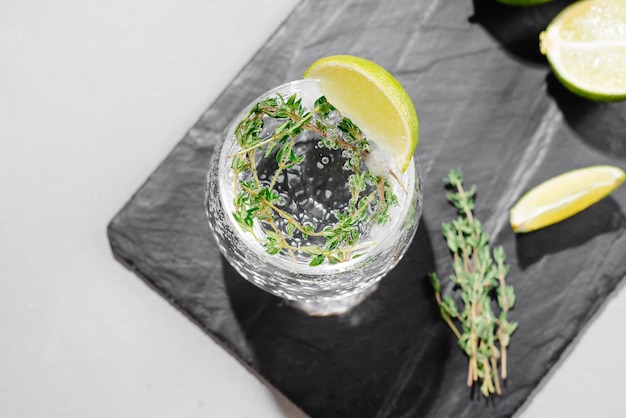 Alcoholic beverage with tonic and lime view from above background gray under concrete