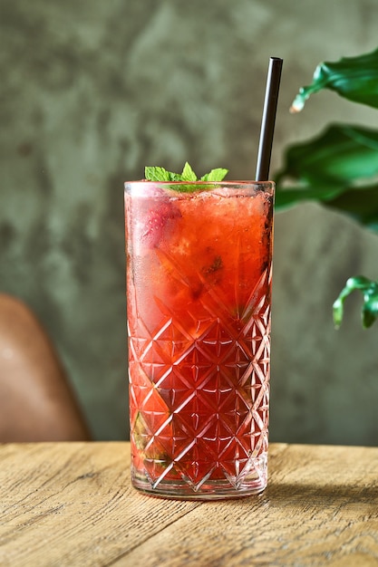 Alcoholic cocktail strawberry mojito with lime and mint in a glass with ice