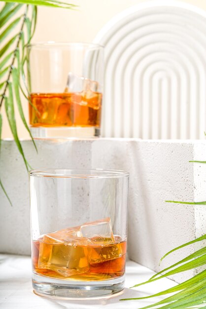 Alcoholic drink cold summer hard strong alcohol cocktail whiskey with ice in short glasses on white background