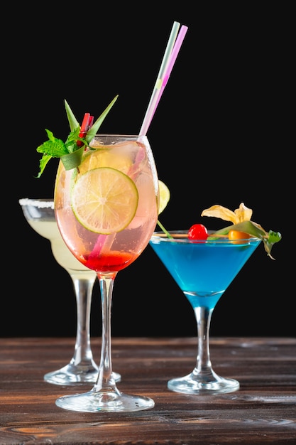 Alcoholic and non alcoholic cocktails on wooden table. Summer cold drinks