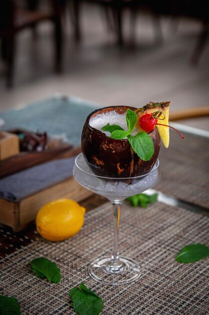 Alcoholic refreshing pina colada cocktail in coconut on the summer terrace of the restaurant