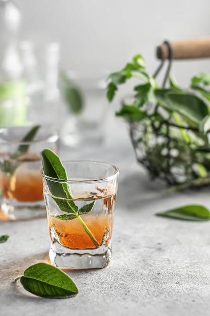 Alcoholic shots double layered decorated with sage on a gray table with copy space