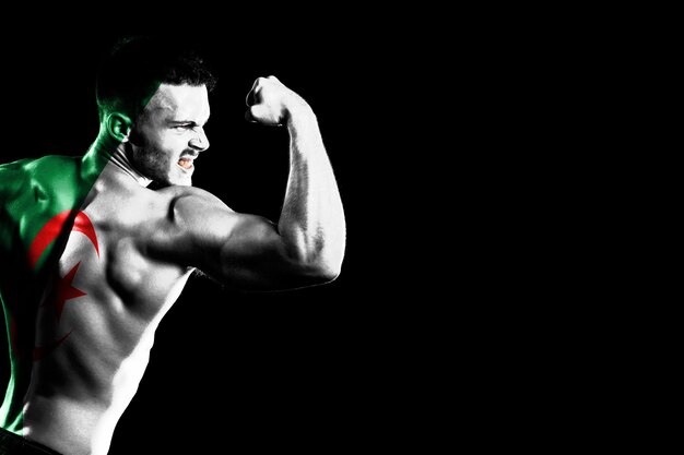 Algeria flag on handsome young muscular man black background