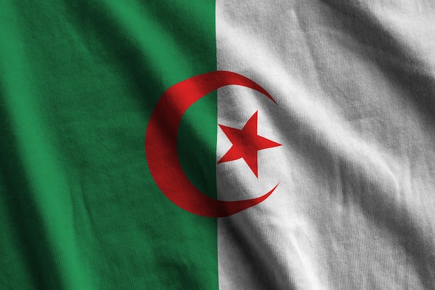 Algeria flag with big folds waving close up under the studio light indoors The official symbols and colors in banner