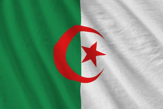 Algeria flag with big folds waving close up under the studio light indoors The official symbols and colors in banner