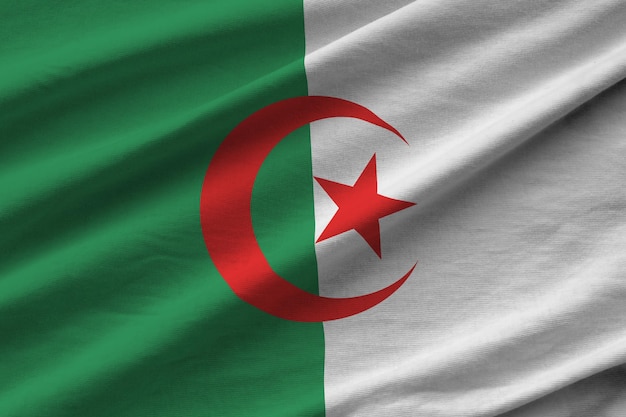 Algeria flag with big folds waving close up under the studio light indoors The official symbols and colors in banner