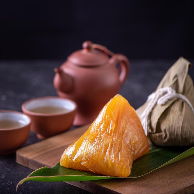 Photo alkaline rice dumpling zongzi traditional sweet chinese crystal food on a plate to eat for dragon boat duanwu festival celebration concept close up