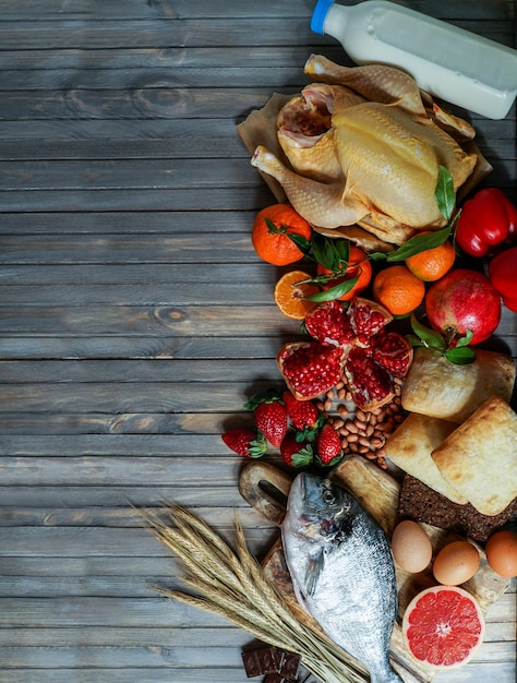 Allergy food concept allergene fish chicken strawberry bread wheat sweet red pepper eggs peanuts citrus wheat flower and others on wooden table top view