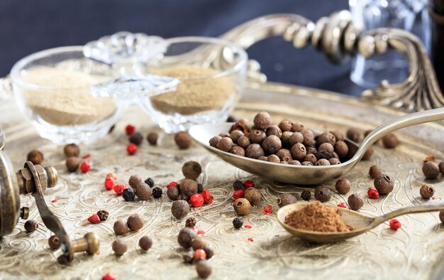 Allspice seeds and powder in spoons