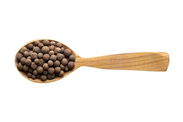 Allspice in wooden spoon isolated on white background spice for cooking food top view