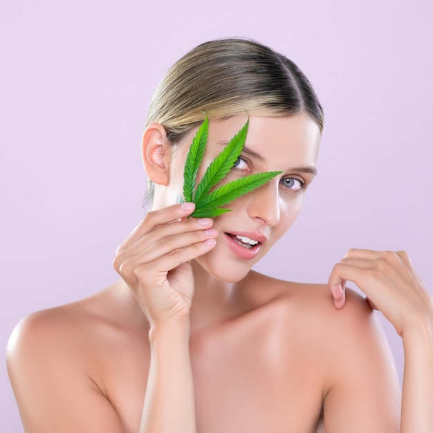 Alluring beautiful woman portrait hold green leaf as cannabis skincare concept