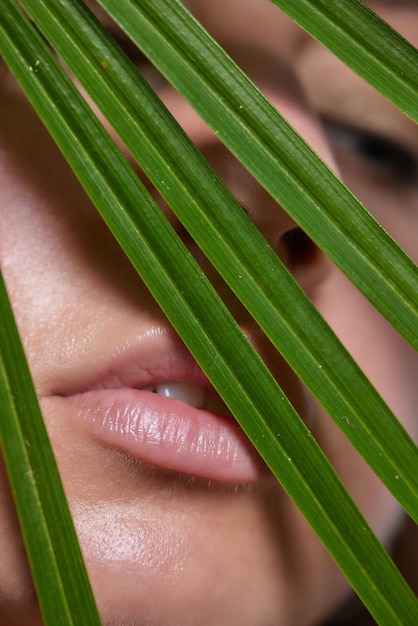 Alluring in good shape bewitching female model over s in sandy clothes cuddling the fern leave durin