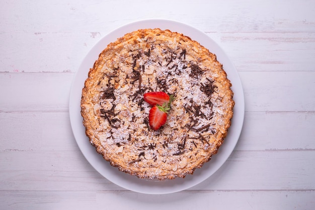 Almond cake with chocolate shavings and strawberry pieces.