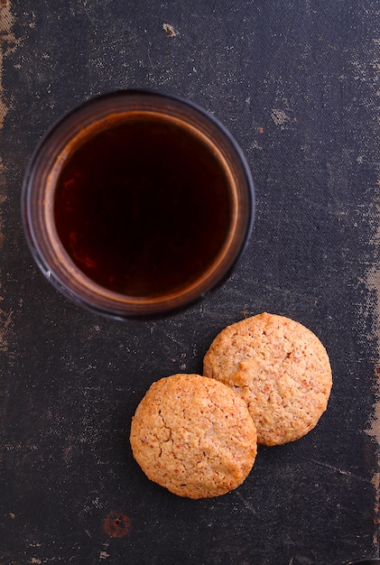 Almond cookies on a black background with a cup of coffee