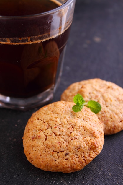 Almond cookies on a black background with a cup of coffee