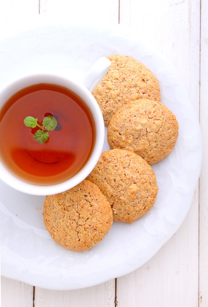 Almond cookies in a white plate with a cup of tea