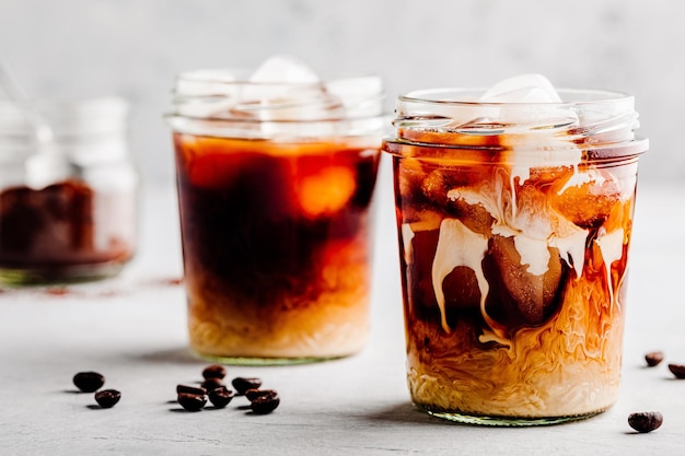 Almond Milk Cold Brew Coffee Latte in glass jar on a gray stone background