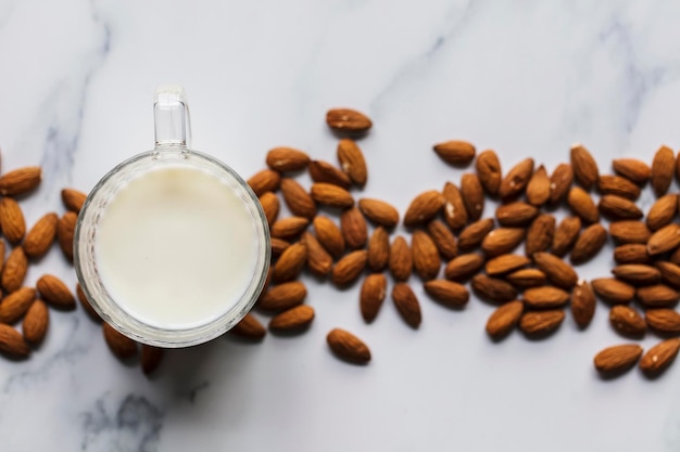 Almond milk in a glass surrounded by organic almonds