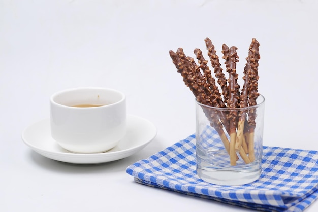 Almond nut dark chocolate stick and cup of tea on white background