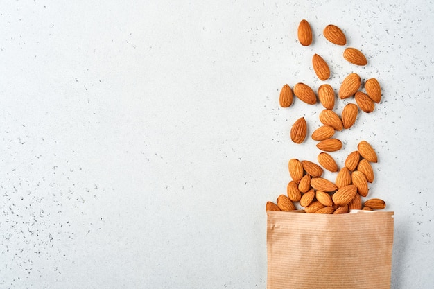 Photo almond nut in paper bag on white background. snack vegan sugarfree food.