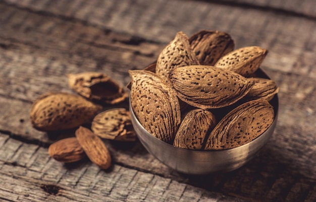 Almond nuts in shell closeup on a wooden background