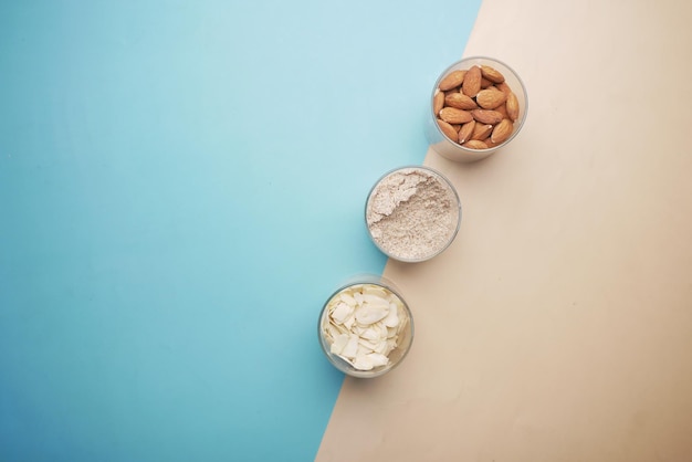 Almond powder and almond in a jar on table