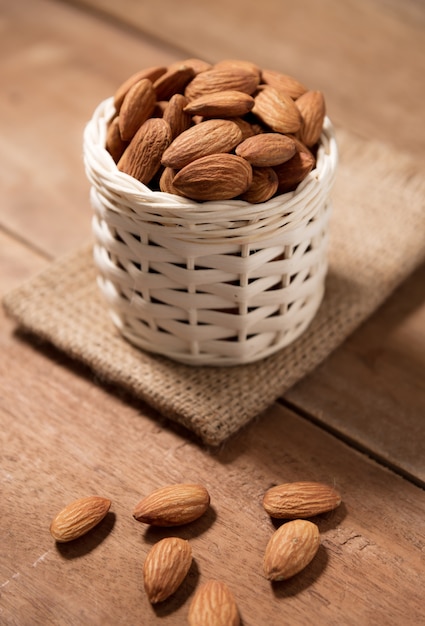 Almond snack fruit in white basket on wooden