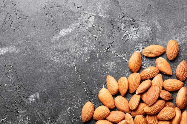 Almonds on a black concrete background close-up. Top view. Place for text.