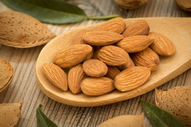 Almonds on brown wooden background