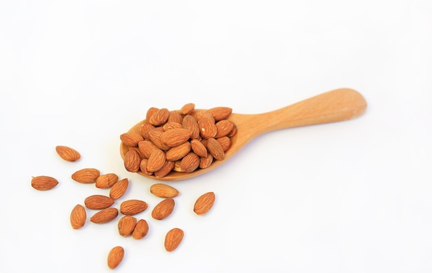 Almonds nuts in wooden spoon isolated on a white background