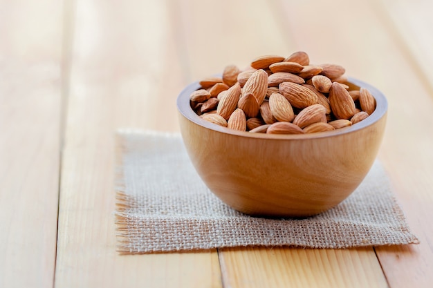 Almonds pour from wood cup