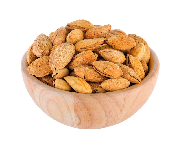 Almonds in wood bowl isolated on white background