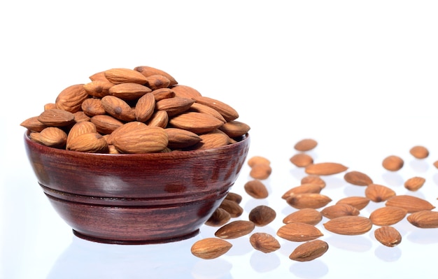 Almonds in a wooden bowl isolated on a white background