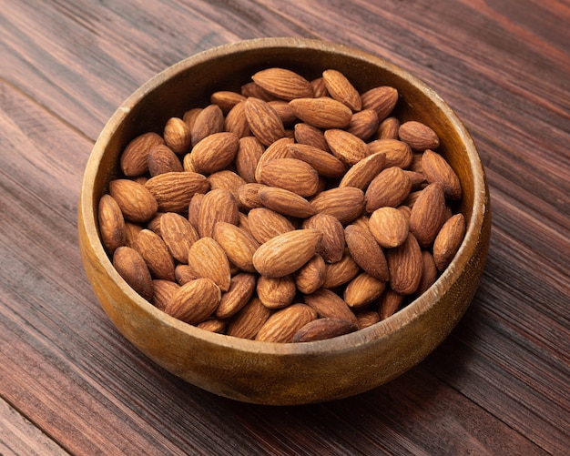 Almonds in wooden bowl on the table, Healthy snack, Vegetarian food.