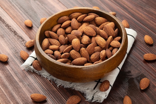 Almonds in wooden bowl on the table, Healthy snack, Vegetarian food.