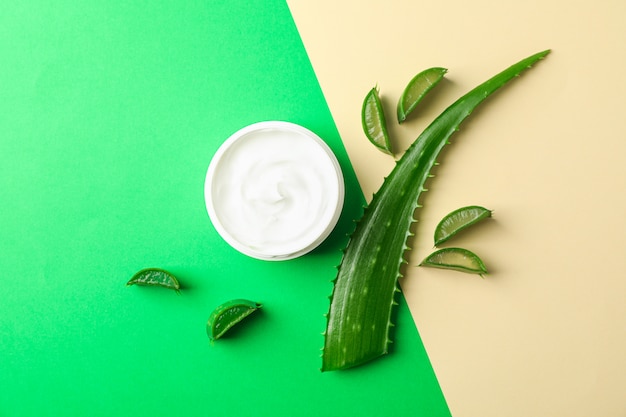 Aloe vera cream, leaves and slices on two tone background, space for text and top view. Natural treatment