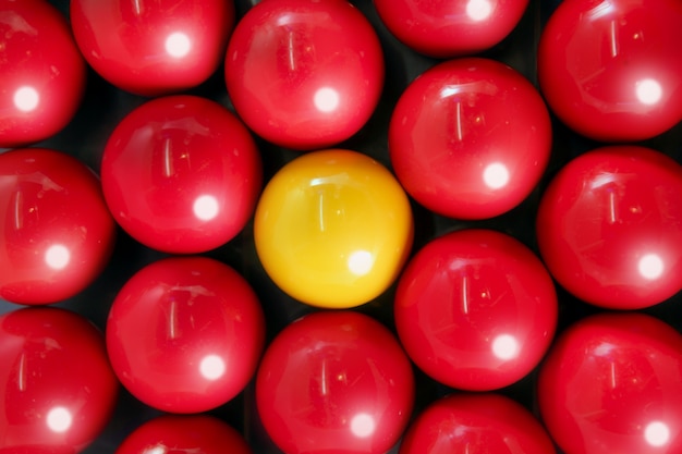 Alone billiard yellow ball between many red balls