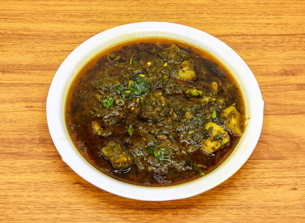 Aloo palak gosht served in plate isolated on table top view of indian and pakistani spicy food