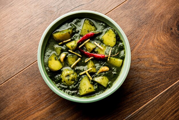 Aloo Palak sabzi or Spinach Potatoes curry served in a bowl. Popular Indian healthy recipe. Selective focus