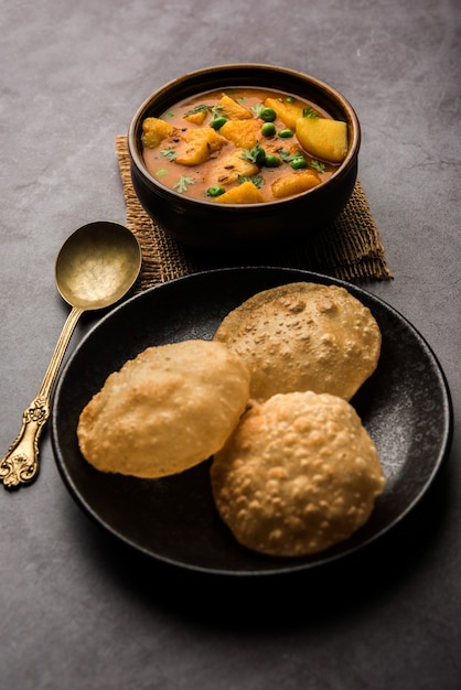 Aloo Puri or Potato curry with fried Poori, popular Indian breakfast or lunch or dinner menu.